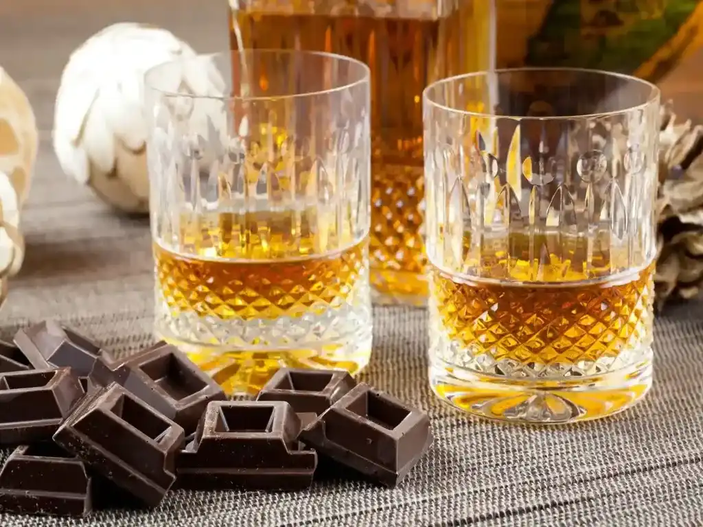 Copos de whisky Cavalo Branco acompanhados de pedaços de chocolate