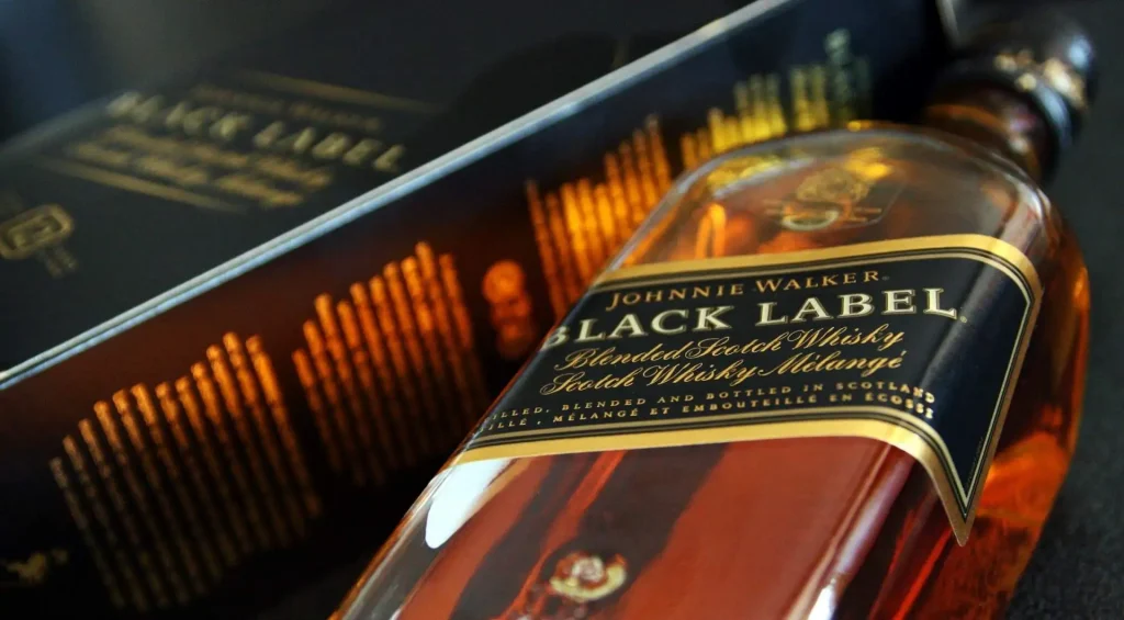 Garrafa de Whisky Johnnie Walker Black Label em um fundo escuro.