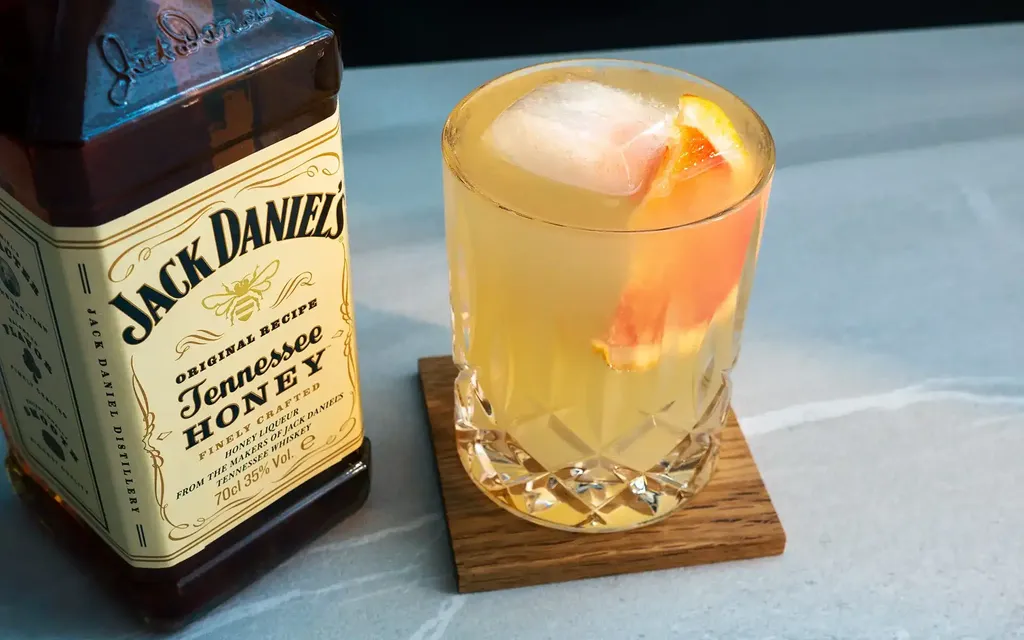 Garrafa de Jack Daniel's Tennessee Honey e copo de Honey Lemonade com gelo.