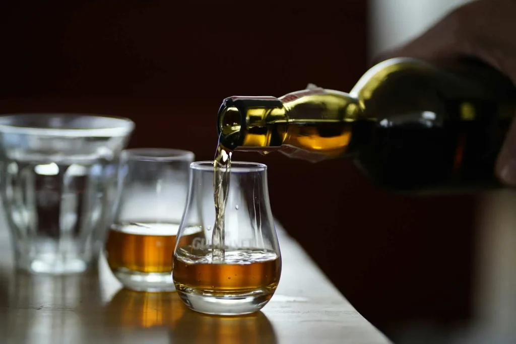 Melhores whiskys do Brasil sendo servidos em copos de degustação.