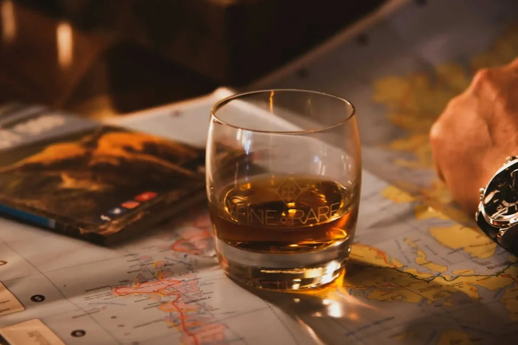 Copo de whisky sobre um mapa da Escócia, representando os melhores whiskys escoceses: 7 escolhas certas.