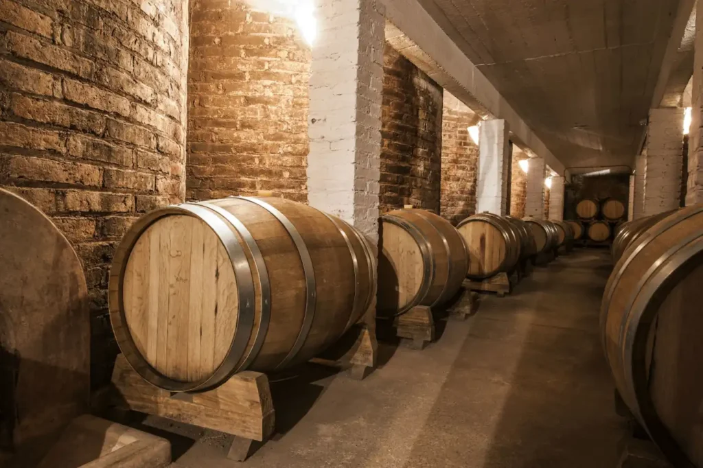 Barris de carvalho armazenados em uma adega, representando o processo de envelhecimento do whisky 1792 Small Batch, conhecido por sua produção em pequenos lotes de menos de 200 barris.