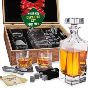 Kit premium de whisky com decantador, copos, pedras geladas e acessórios organizados em caixa de madeira.